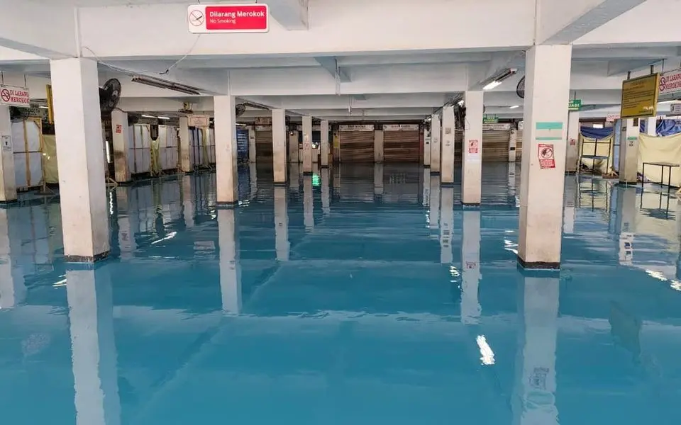 Lantai epoxy biru mengilap di area parkir yang sudah selesai dikerjakan