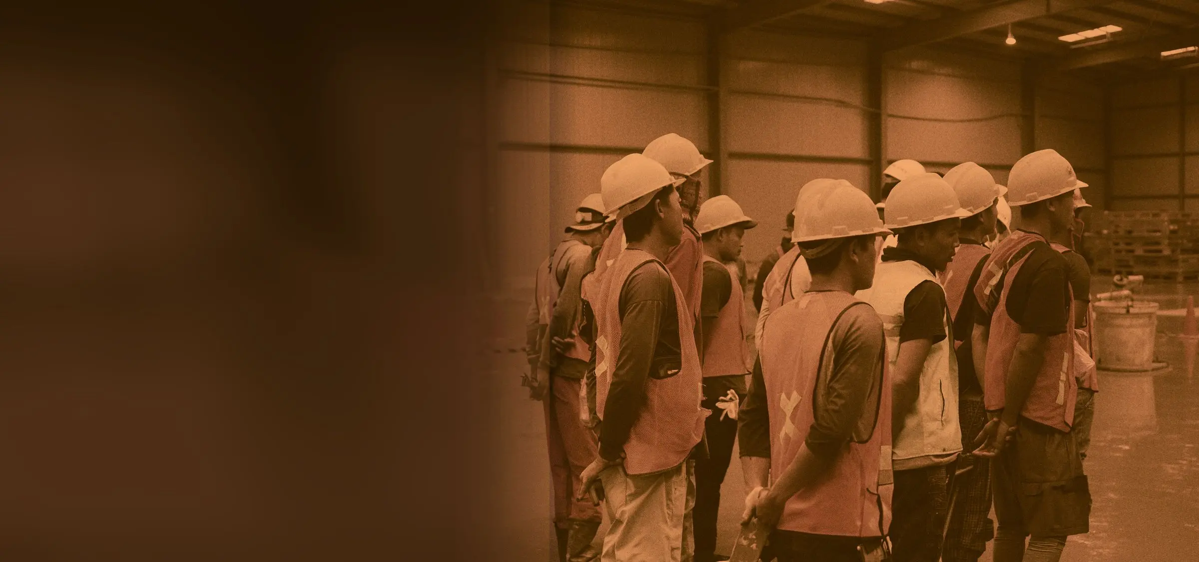 Tim aplikator berhelm dan berompi keselamatan berkumpul di lantai gudang