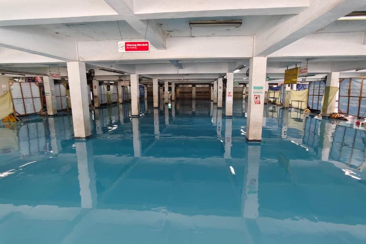 Lantai epoxy biru di gudang Pelindo Tanjung Priok, memanjang di antara deretan kolom