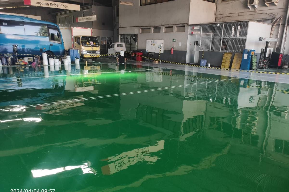 Area servis PT Salindo Berlian Motor dengan lantai epoxy hijau dan truk di atas dongkrak