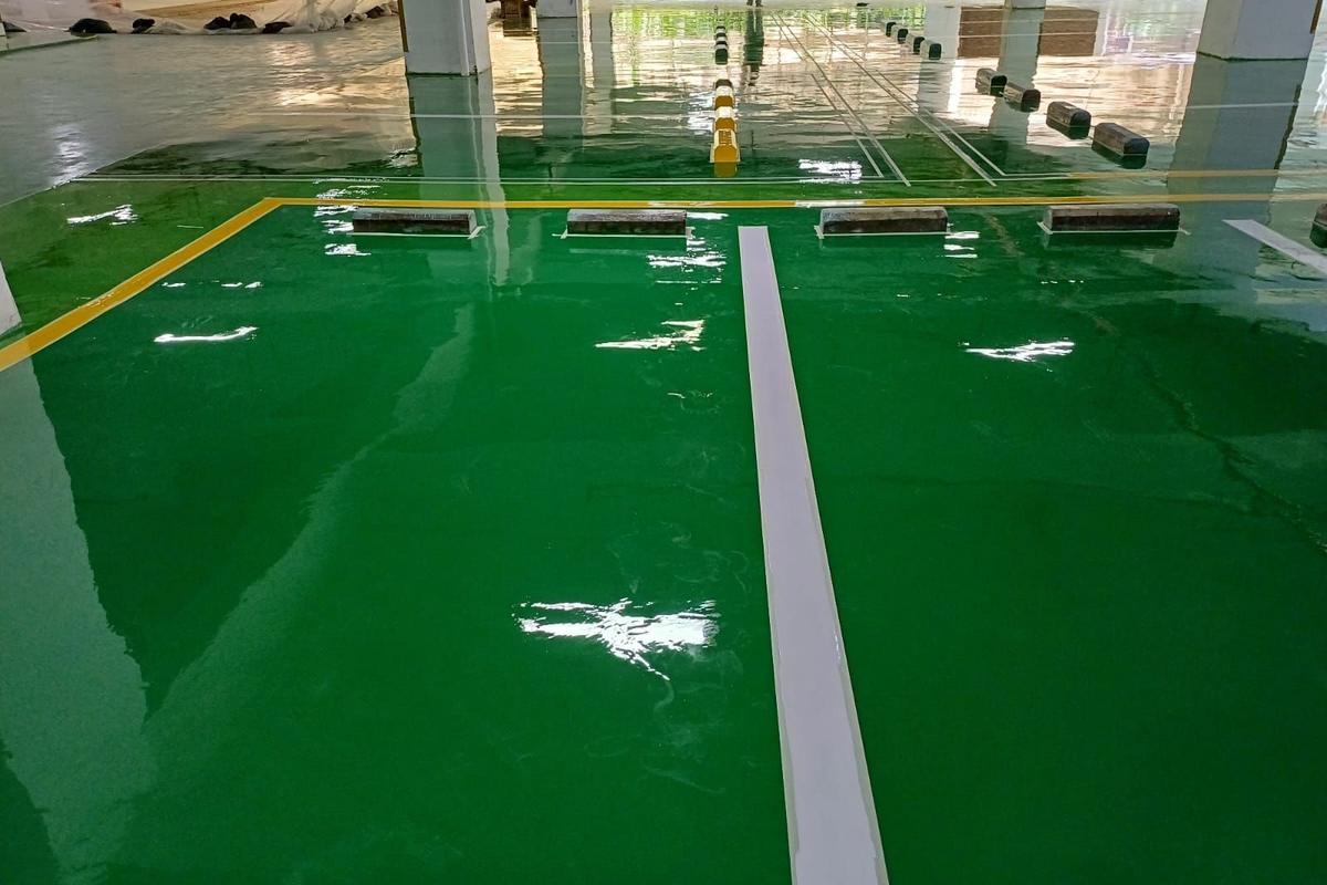 Basement parkir Springhill Royale Suites dengan lantai epoxy hijau dan marka jalur putih