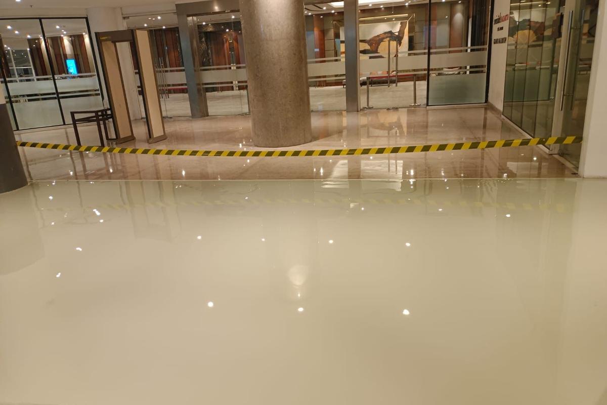 Koridor Swissotel Jakarta PIK Avenue dengan lantai epoxy krem yang memantulkan lampu