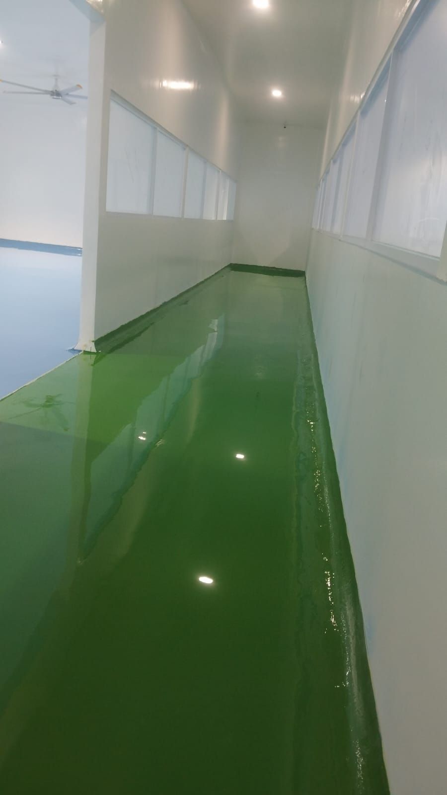 Ruang produksi Agarindo dengan lantai epoxy biru muda dan saluran air di tengah ruang (3/4)