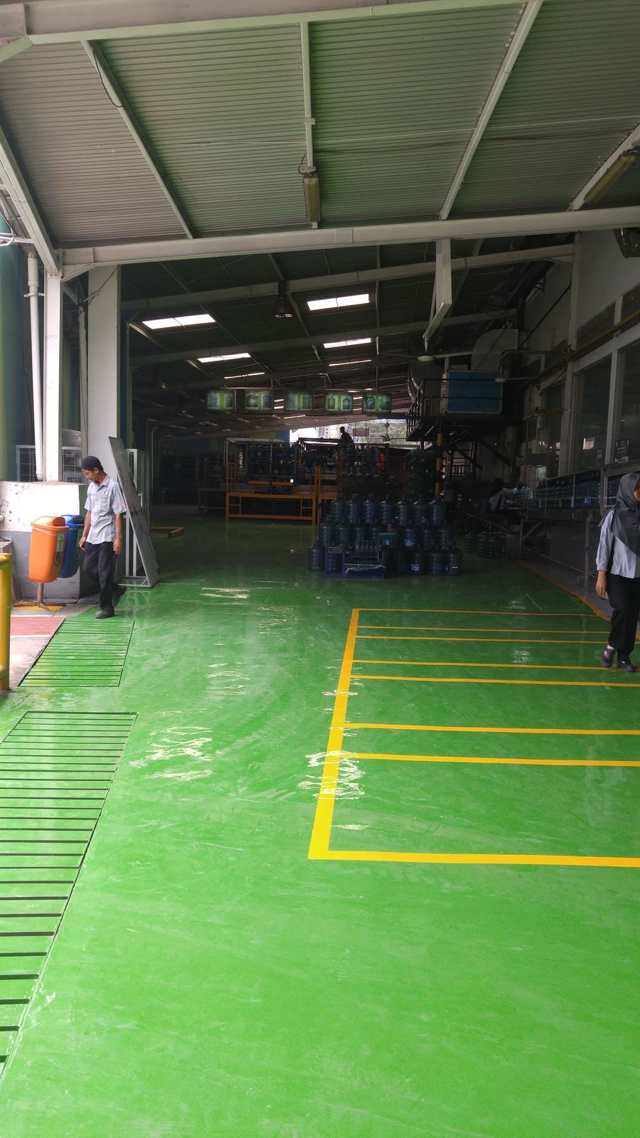 Area produksi Aqua Citeureup dengan lantai epoxy hijau dan marka jalur kuning