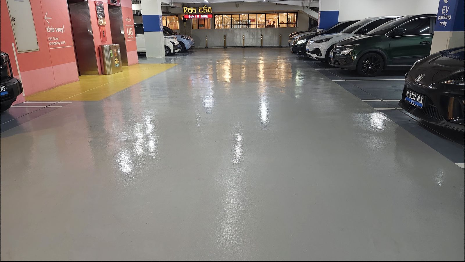 Lantai parkir Blok M Plaza dengan epoxy abu-abu dan marka jalur kuning