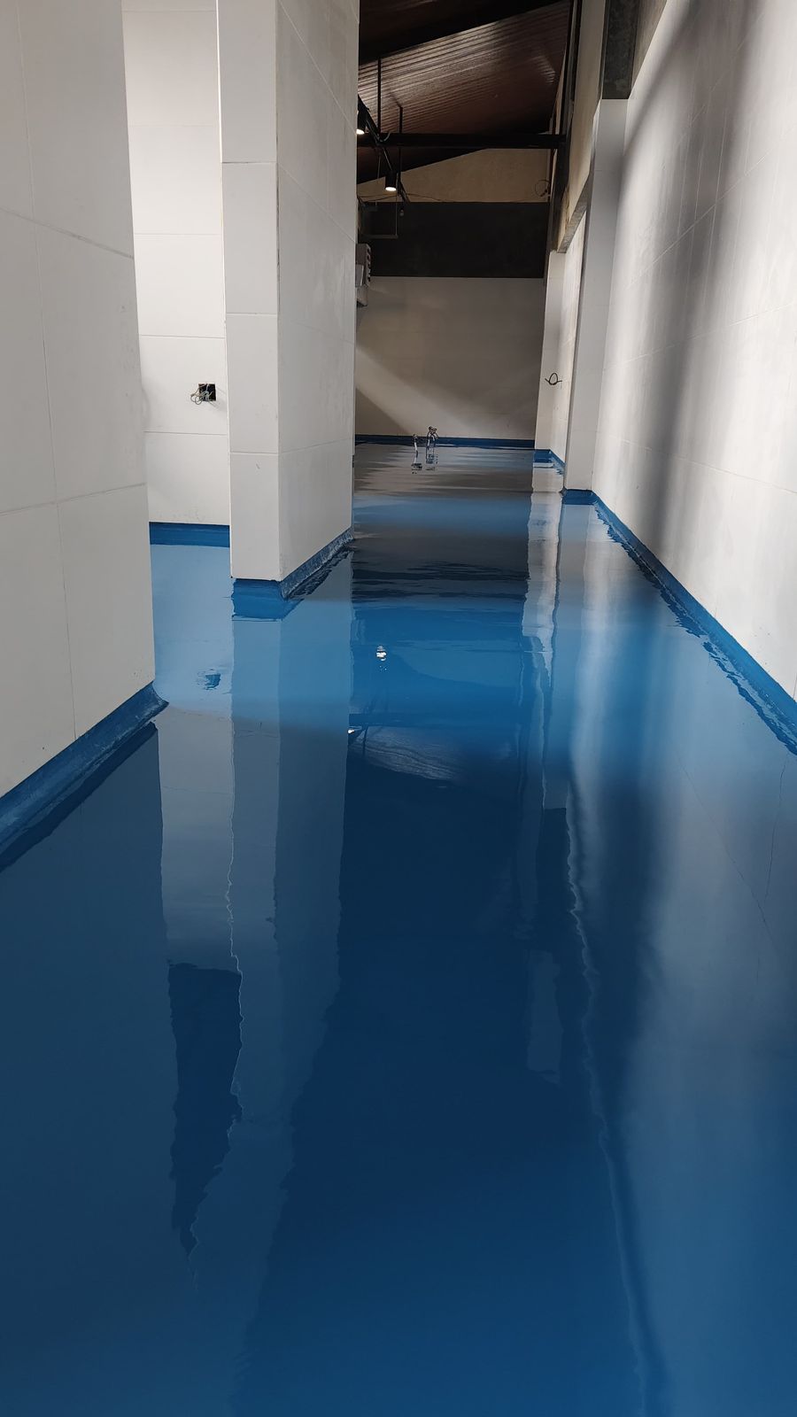 Koridor produksi PT Cimory dengan lantai epoxy biru dan dinding putih