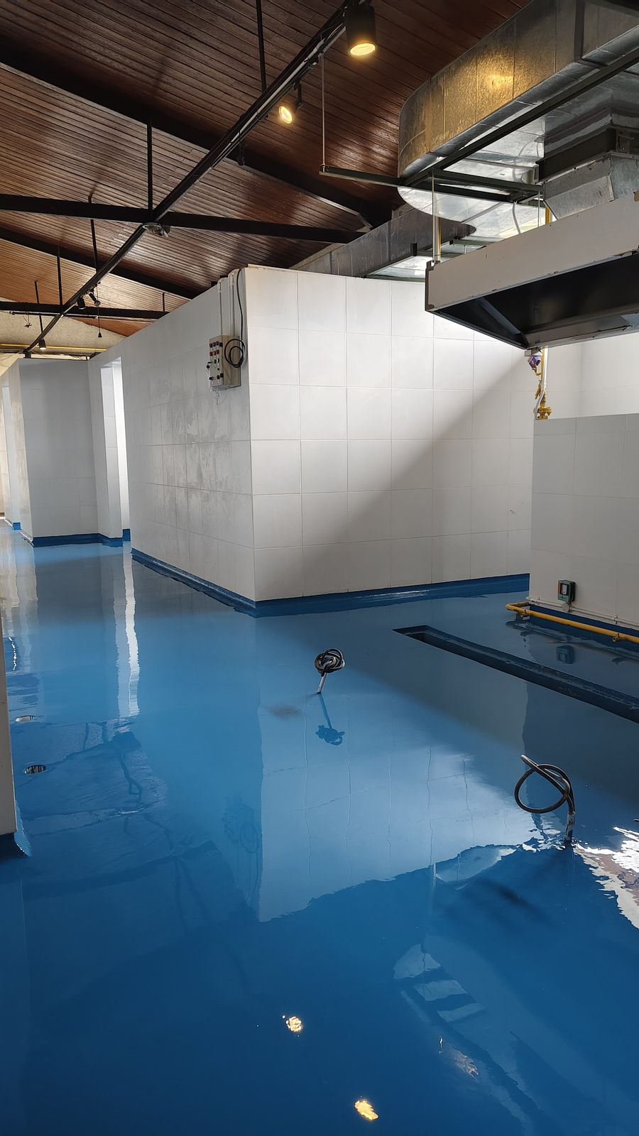Koridor produksi PT Cimory dengan lantai epoxy biru dan dinding putih (2/4)