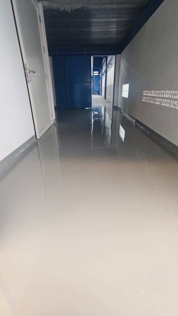 Ruang produksi Cipta Rasa Sempurna dengan lantai epoxy putih memantulkan deretan jendela (5/7)