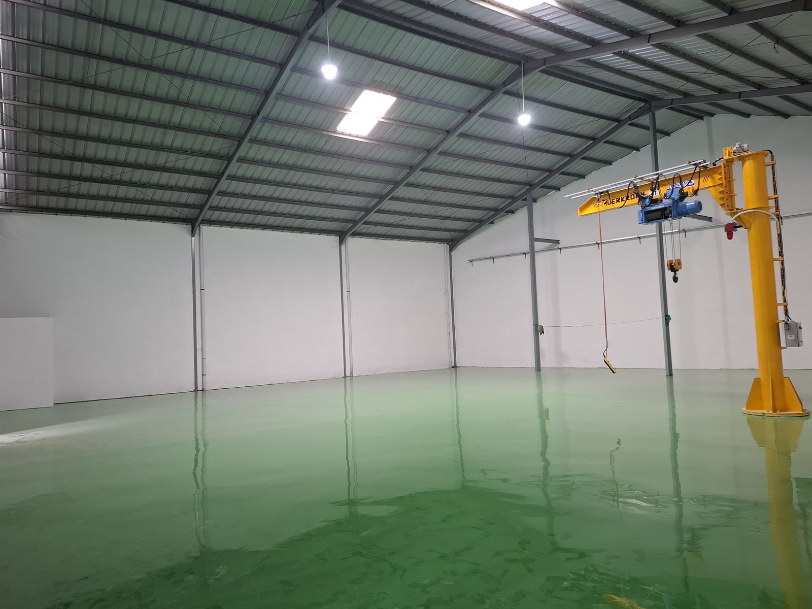 Lantai epoxy hijau di bawah jib crane kuning pada pabrik Daeshin Flange Fitting Industri (2/6)
