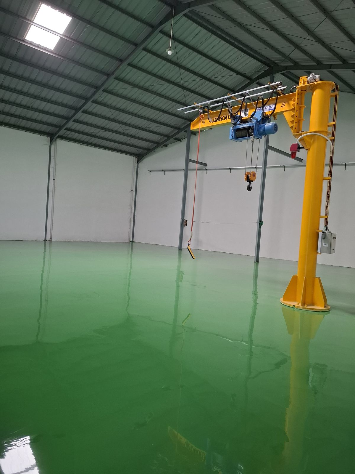 Lantai epoxy hijau di bawah jib crane kuning pada pabrik Daeshin Flange Fitting Industri (4/6)