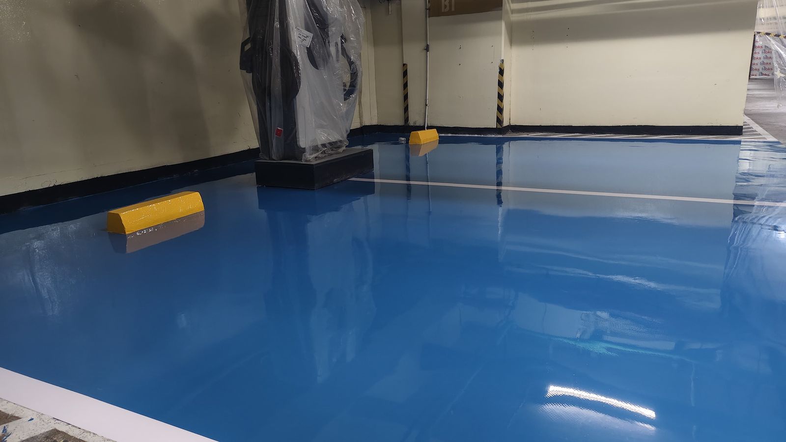 Lantai epoxy biru dengan marka jalur putih di area servis PT Deqha (2/4)