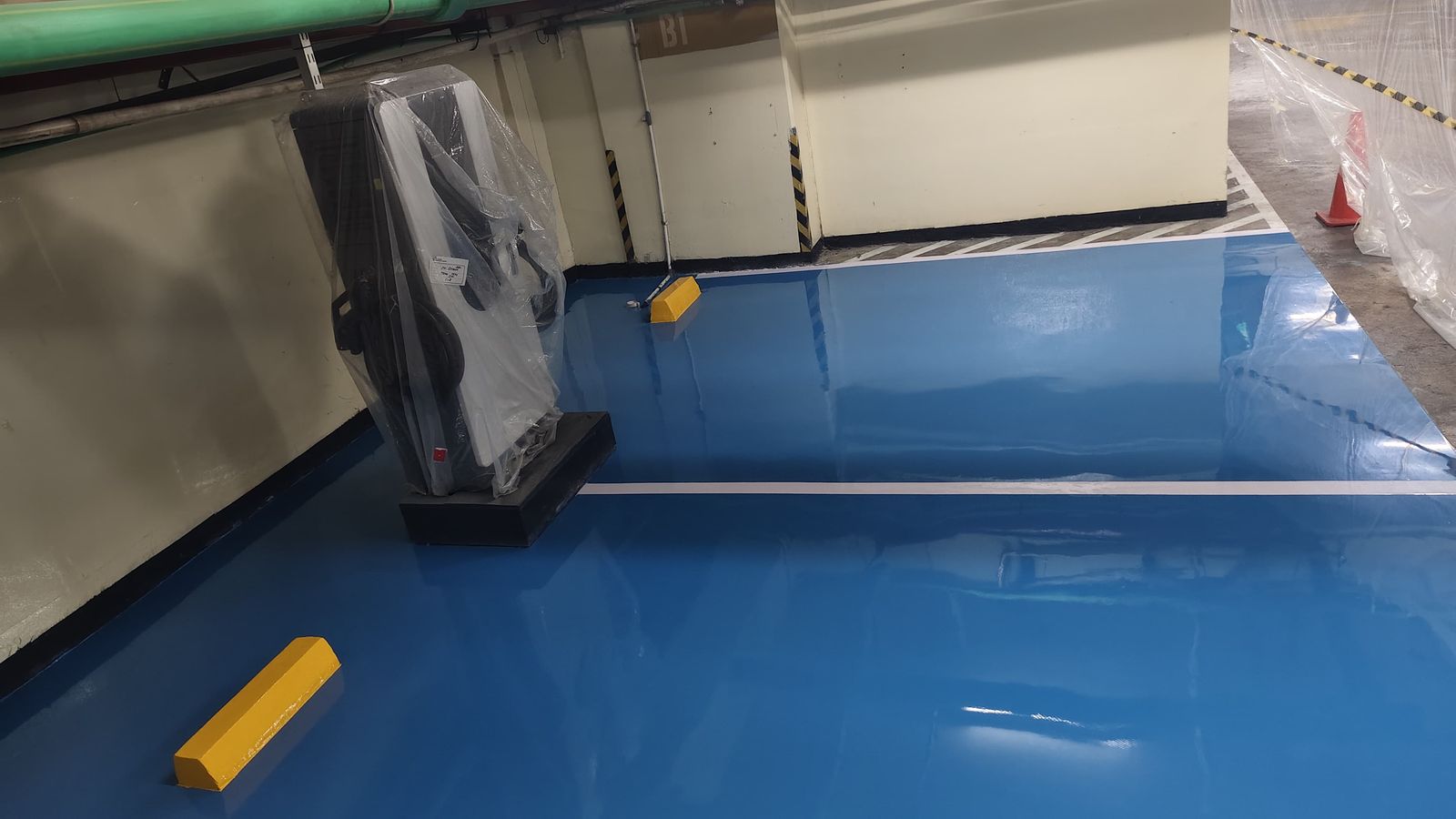 Lantai epoxy biru dengan marka jalur putih di area servis PT Deqha (4/4)