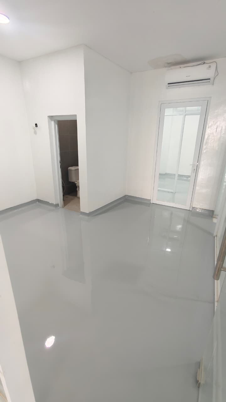Koridor klinik Dora Medika Utama dengan lantai epoxy abu-abu muda tanpa sambungan