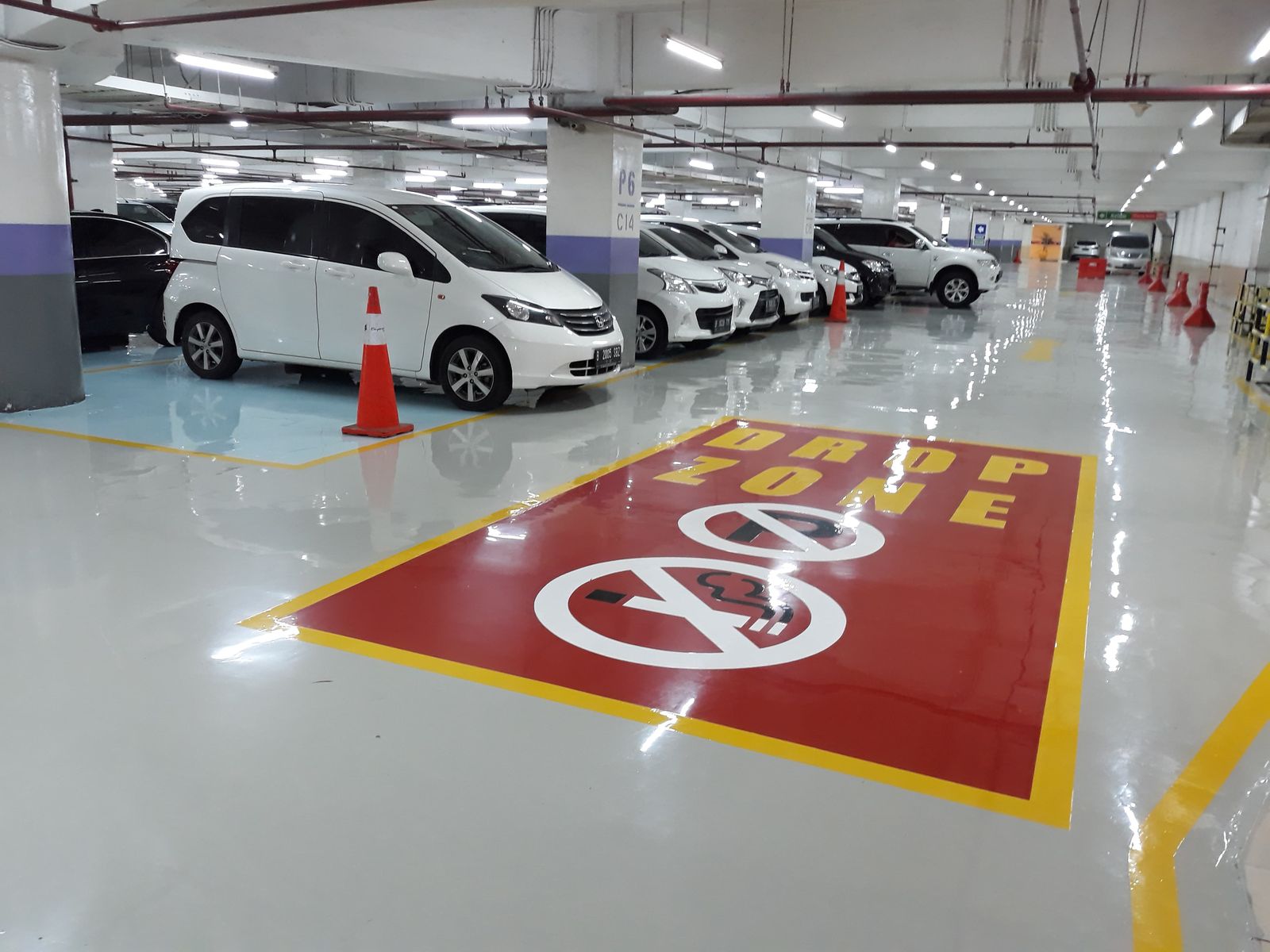 Zona parkir merah di Emporium Pluit dengan rambu lantai dan mobil terparkir