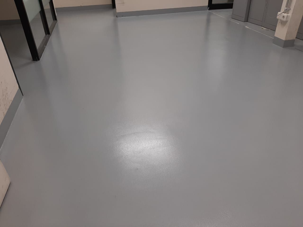 Aplikator memoles lantai epoxy abu-abu di koridor servis Fairmont Jakarta (3/3)