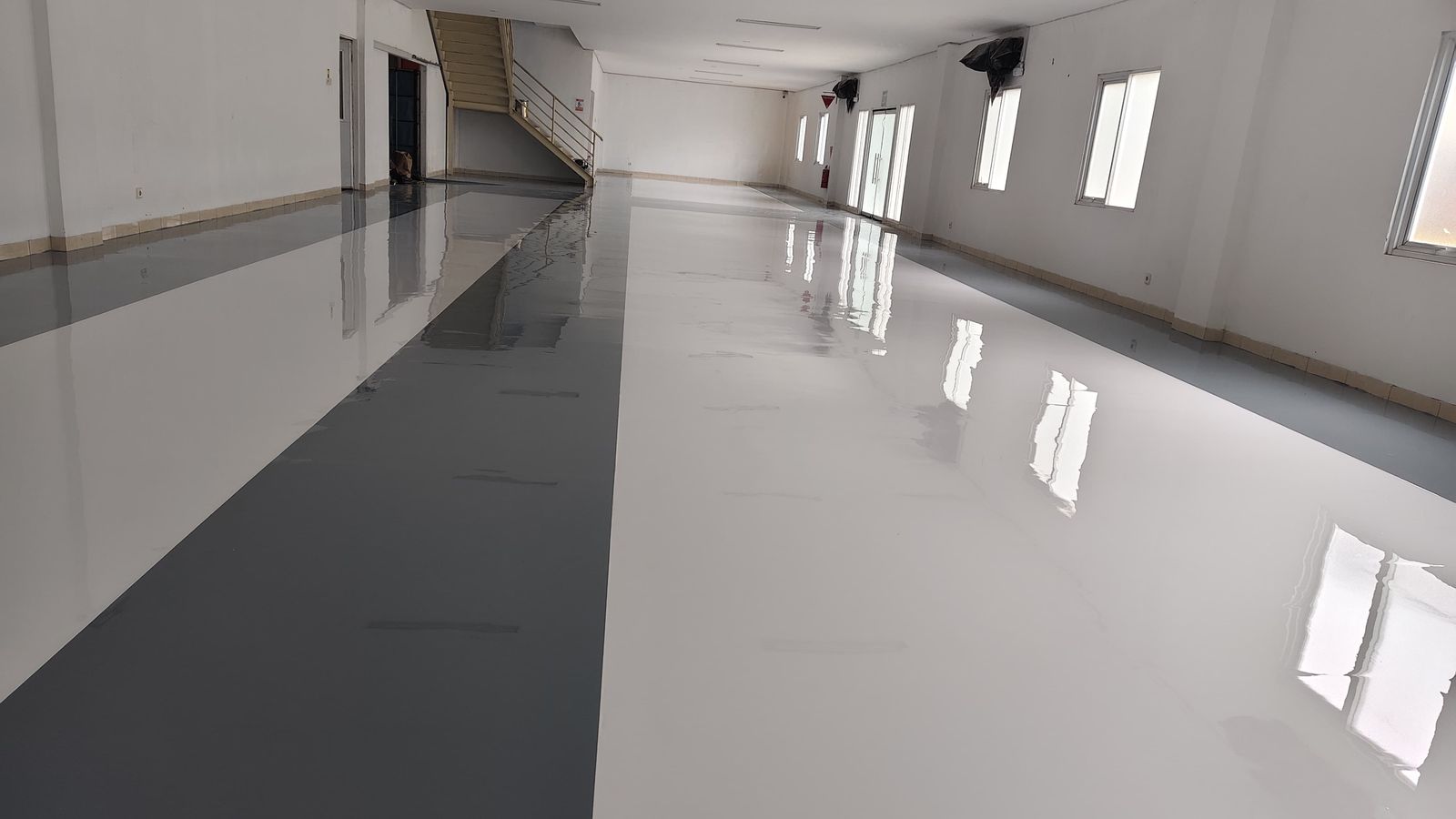 Lantai epoxy dua warna, putih dan abu-abu, di ruang produksi Fuji Kensetsu