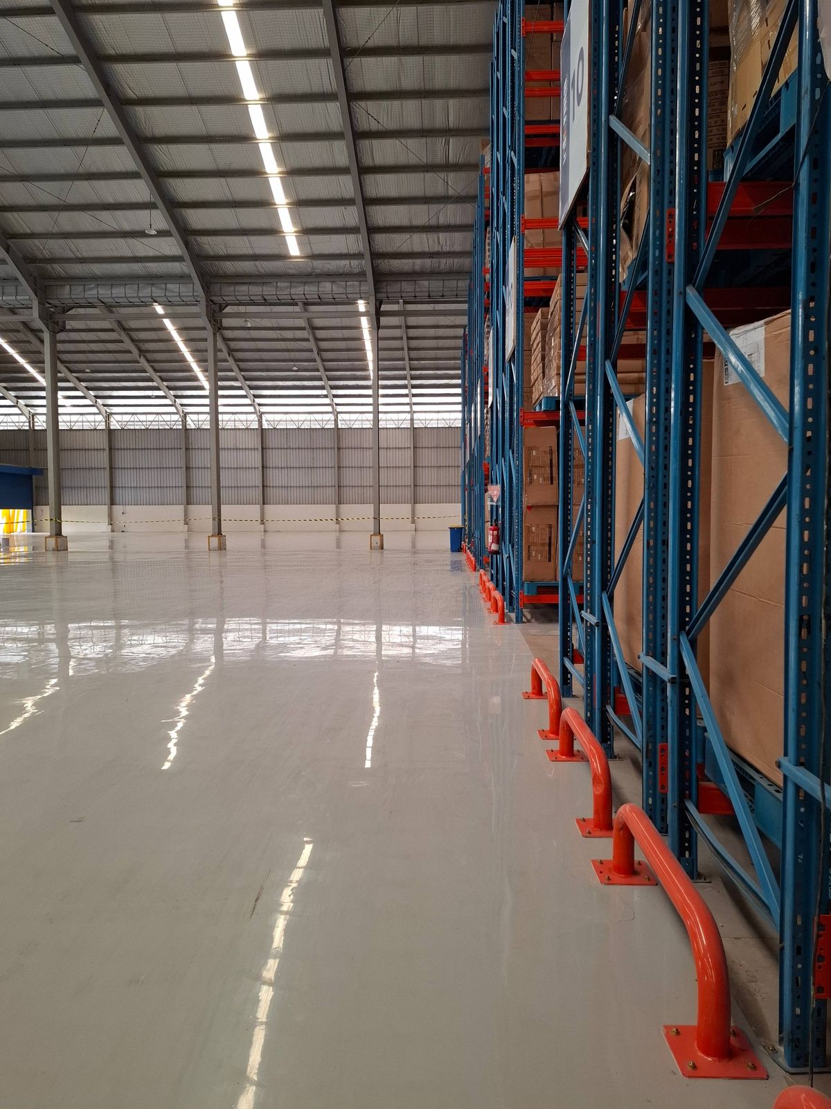 Gudang Genesis Cikarang dengan lantai epoxy abu-abu di antara rak tinggi (9/10)