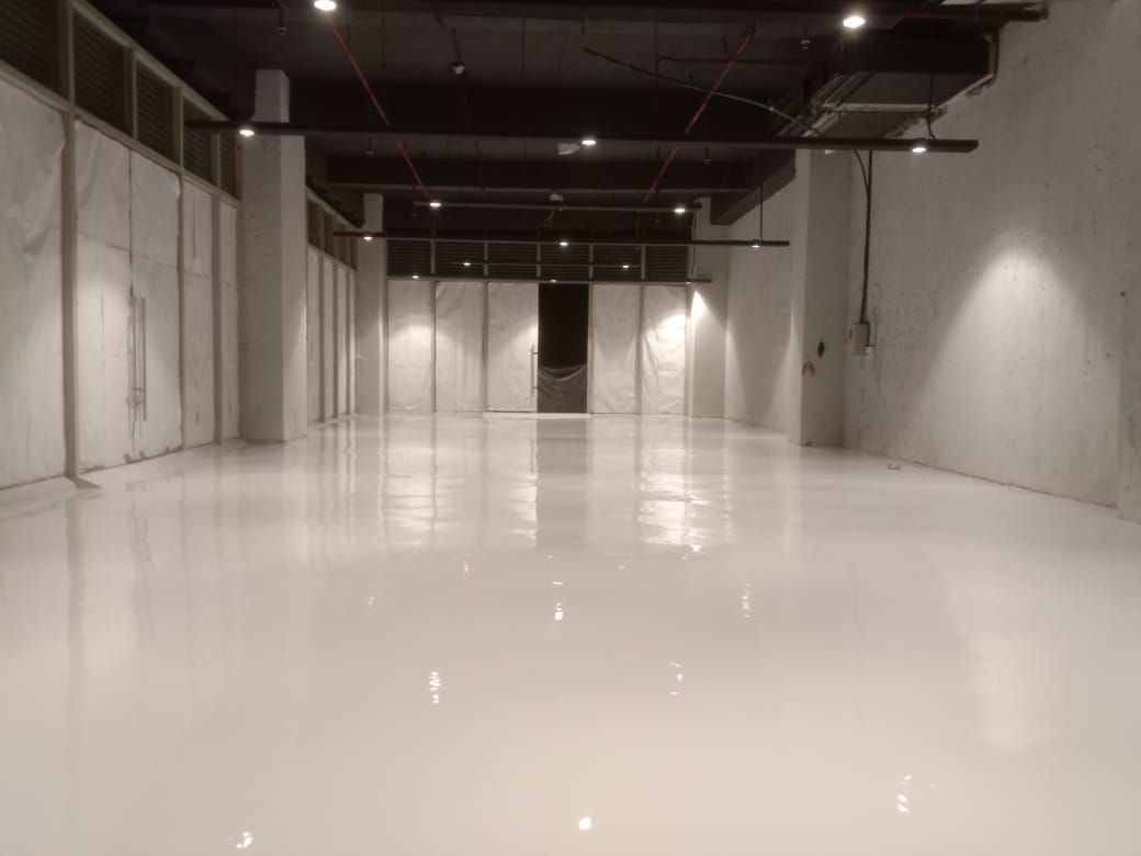 Unit ritel kosong di Grand Galaxy Park dengan lantai epoxy abu-abu muda