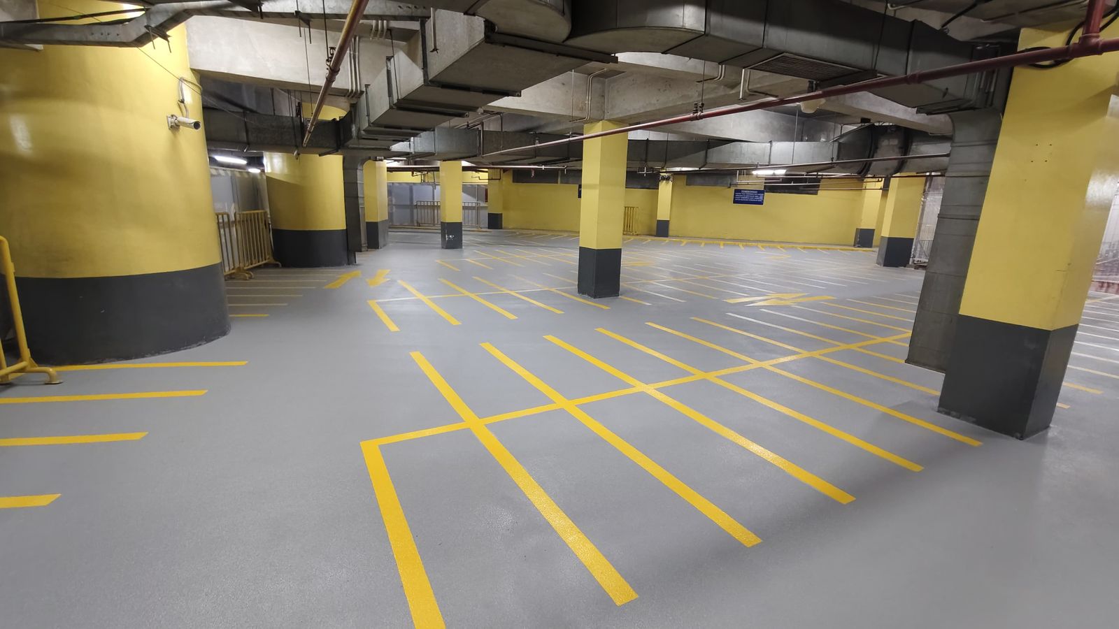 Basement parkir Grand Indonesia dengan grid marka kuning dan kolom bercat kuning (2/4)