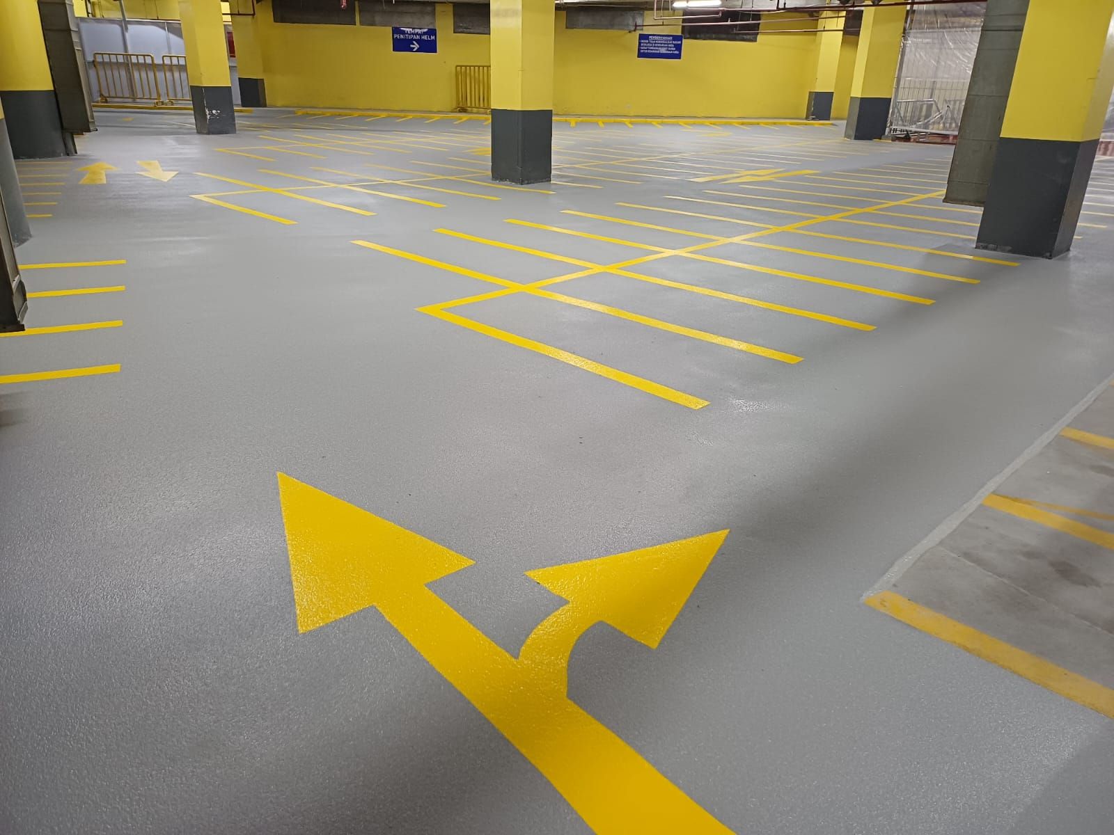 Basement parkir Grand Indonesia dengan grid marka kuning dan kolom bercat kuning (3/4)