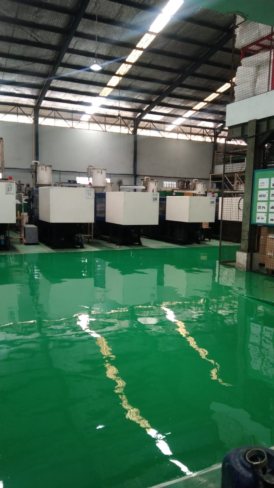 Lantai epoxy hijau dengan marka jalur kuning di antara mesin Hinomoto Indonesia