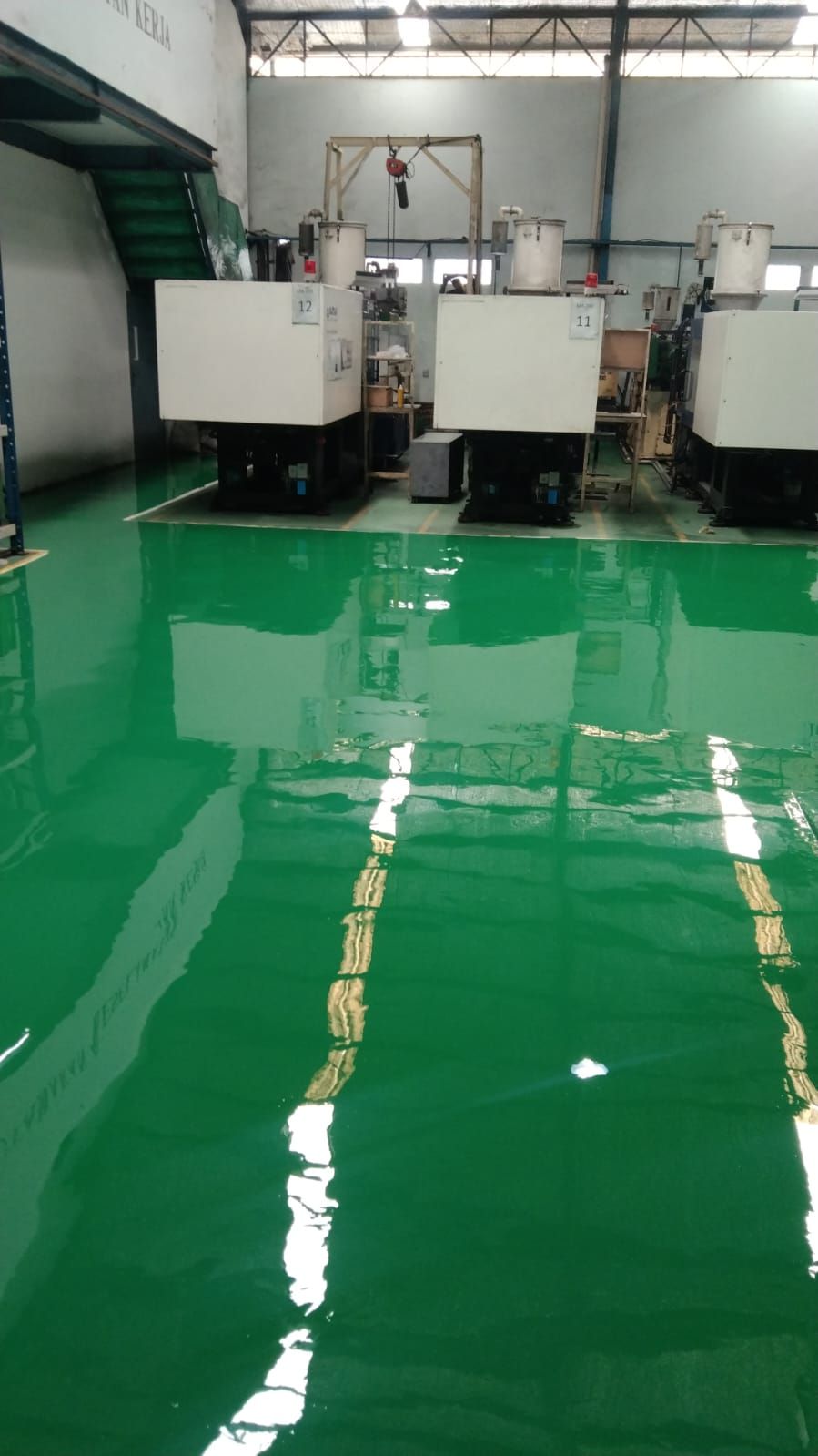 Lantai epoxy hijau dengan marka jalur kuning di antara mesin Hinomoto Indonesia (3/3)