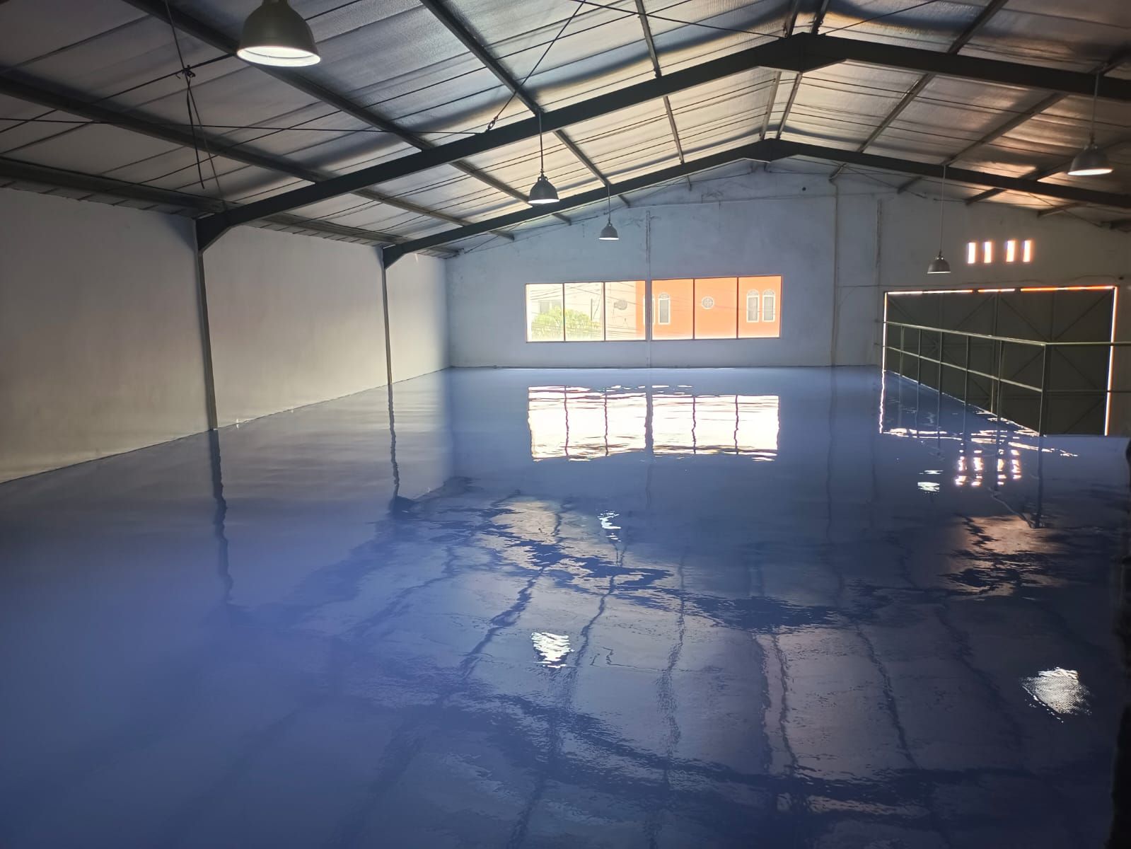 Gudang PT Imexindo dengan lantai epoxy biru yang memantulkan bukaan cahaya atap