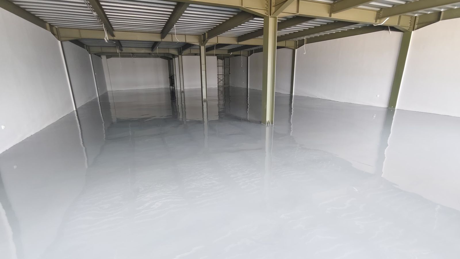 Ruang produksi Inti Berkat Jaya dengan lantai epoxy abu-abu muda dan rangka baja terbuka (2/3)