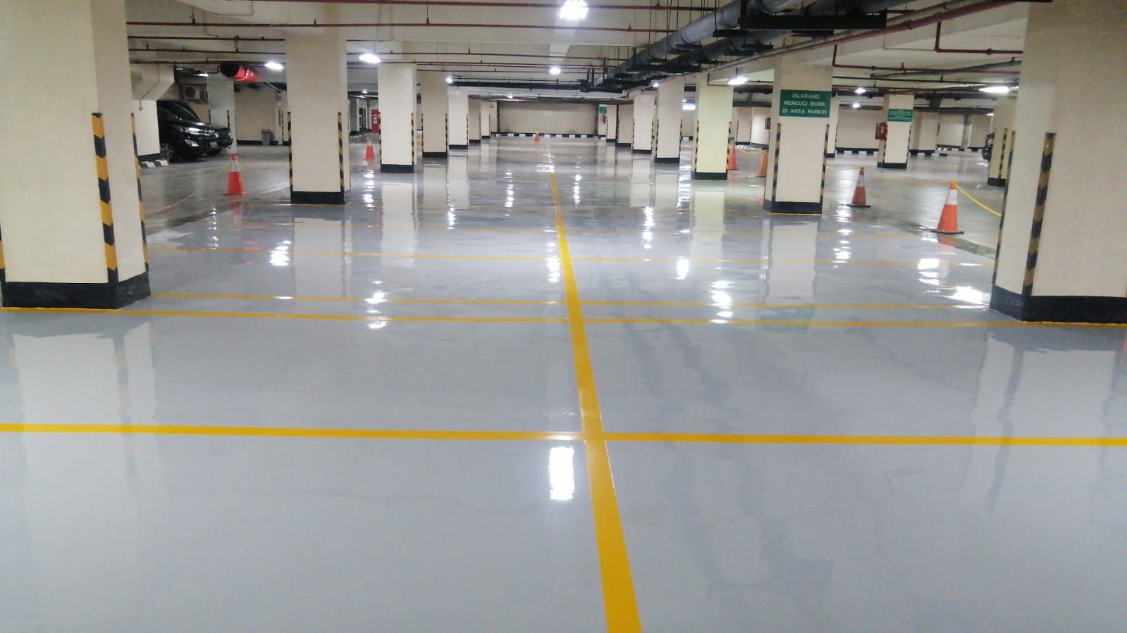 Marka chevron hitam kuning mengelilingi tugu granit di lantai parkir Jakarta Stock Exchange (3/8)