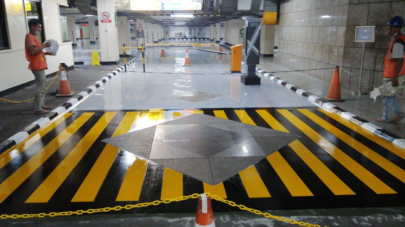 Marka chevron hitam kuning mengelilingi tugu granit di lantai parkir Jakarta Stock Exchange