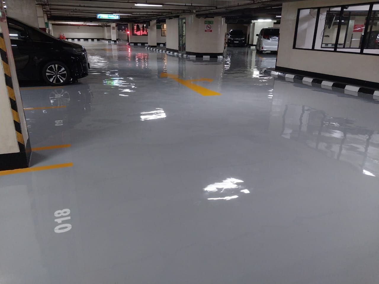 Marka chevron hitam kuning mengelilingi tugu granit di lantai parkir Jakarta Stock Exchange (7/8)