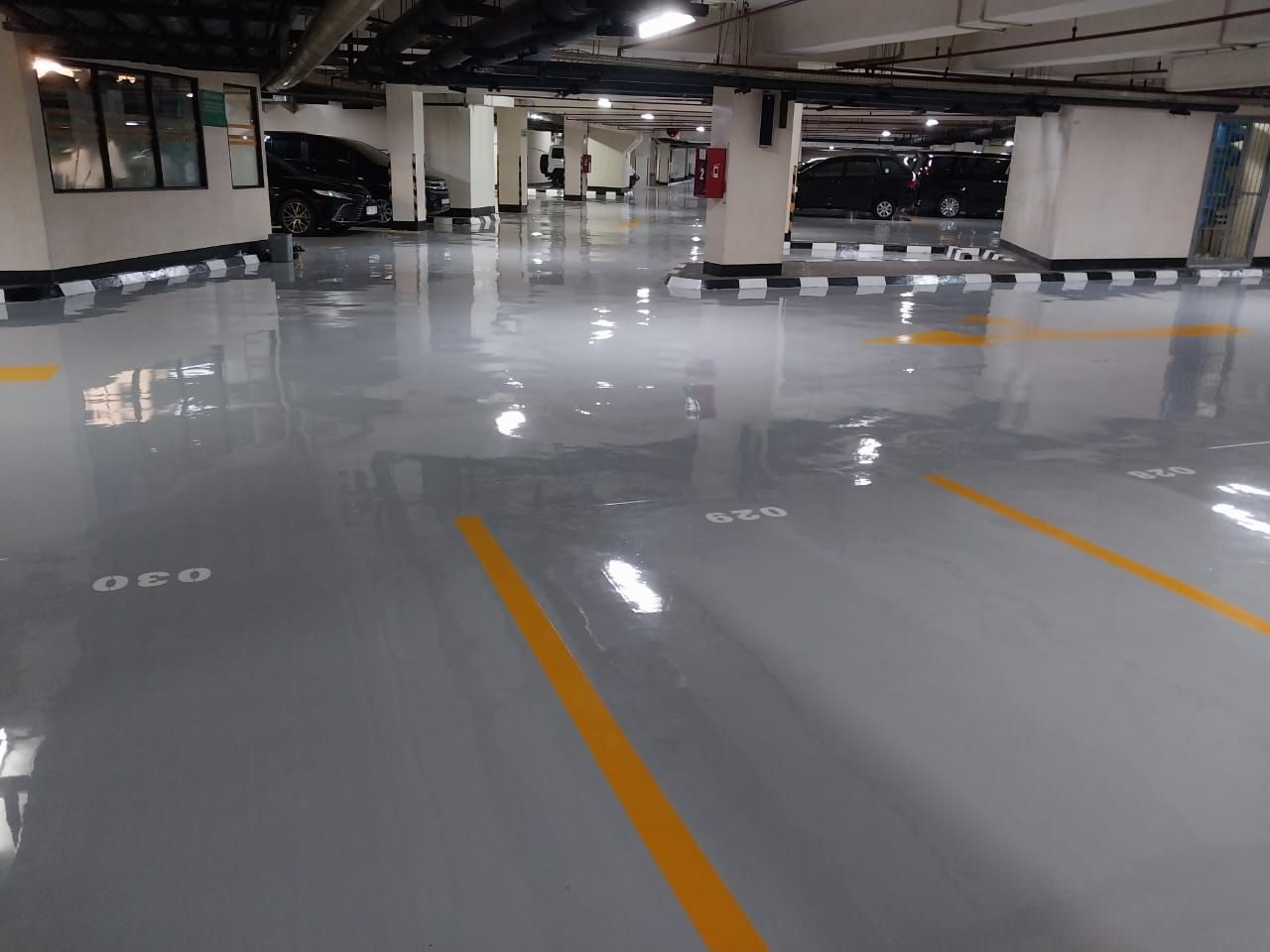 Marka chevron hitam kuning mengelilingi tugu granit di lantai parkir Jakarta Stock Exchange (8/8)