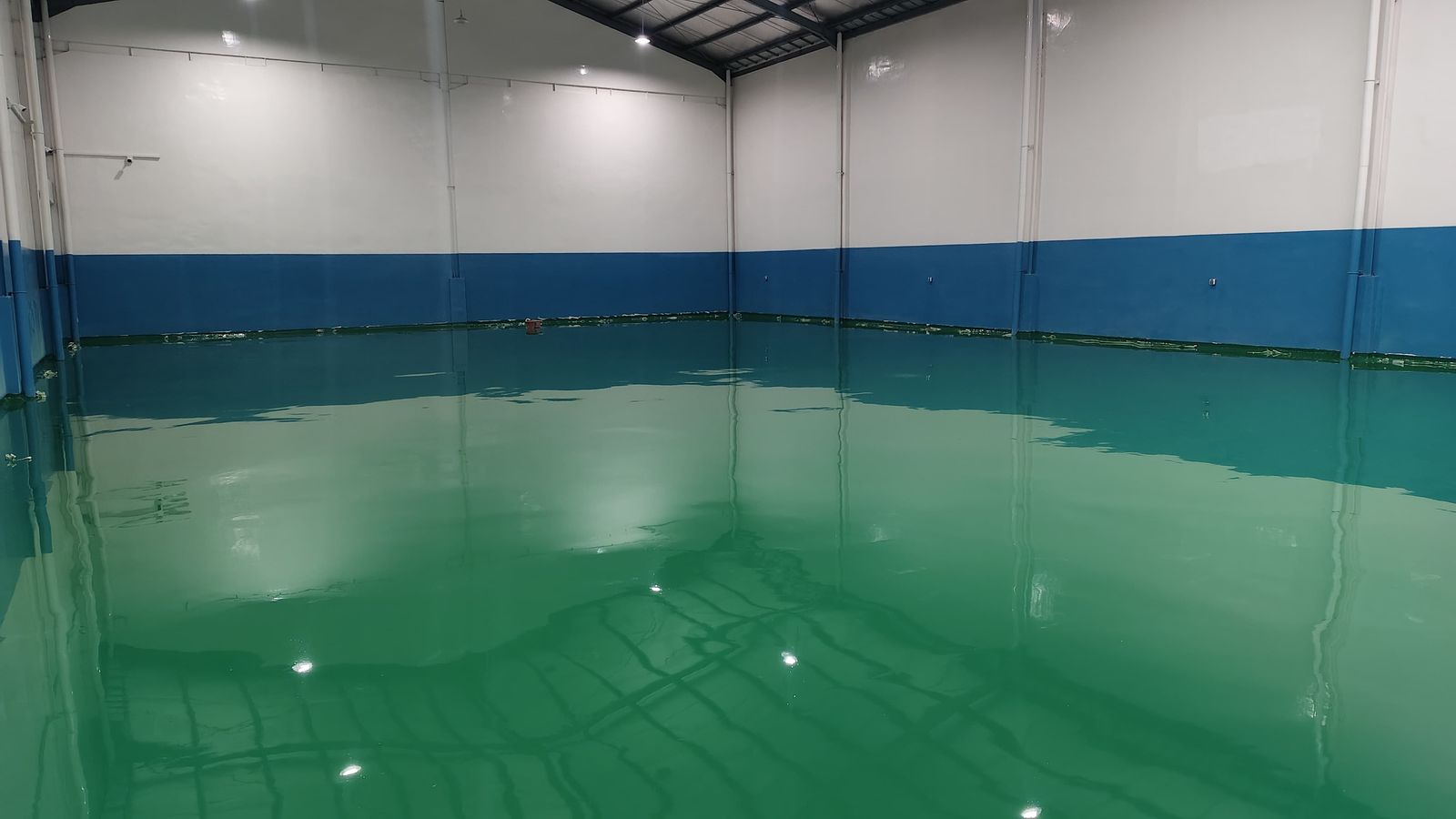 Lantai epoxy hijau dengan dinding biru di ruang produksi Jaya Kreasi (2/4)
