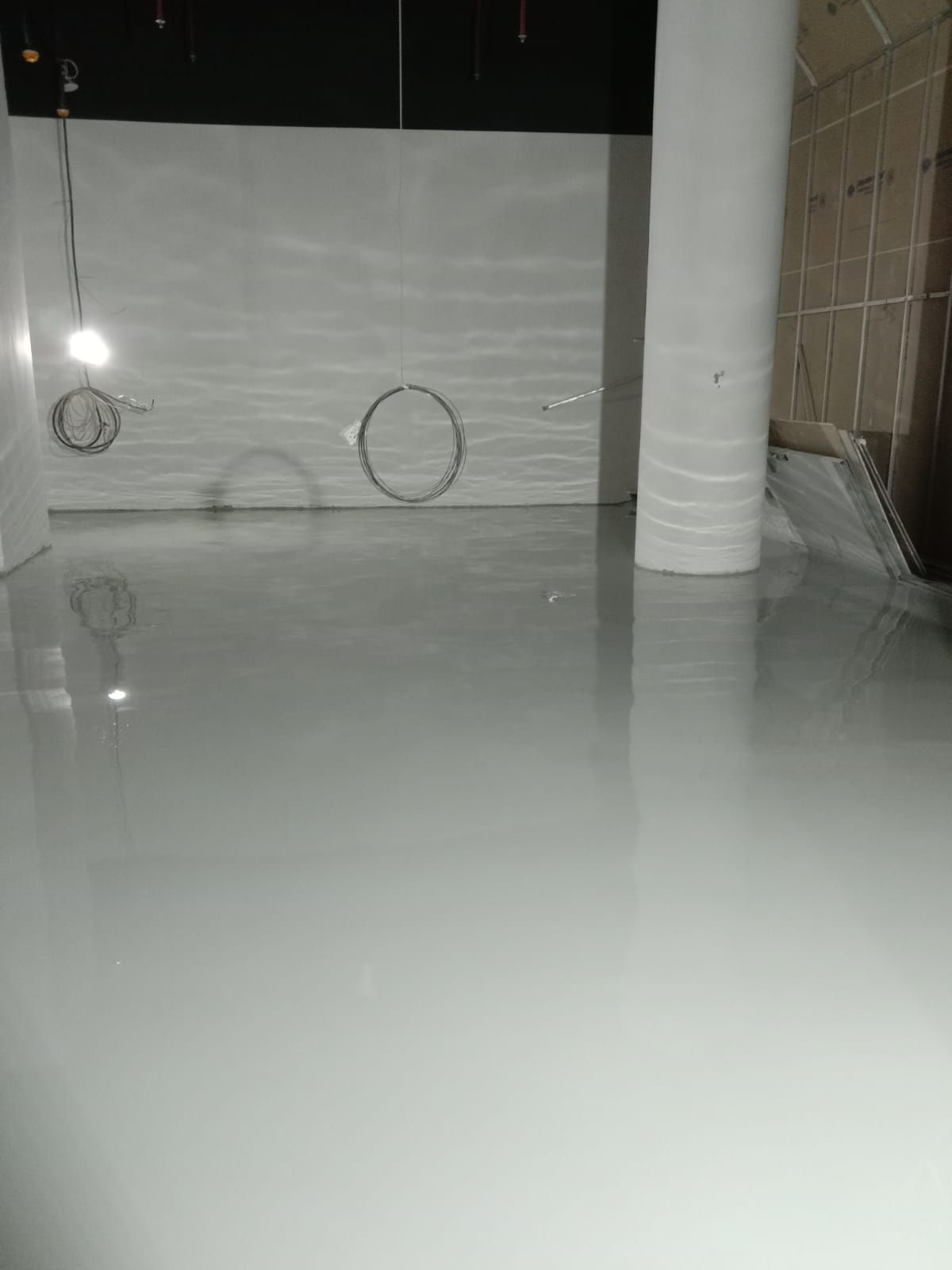 Lantai parkir K Mall dengan epoxy abu-abu di antara kolom beton (2/3)