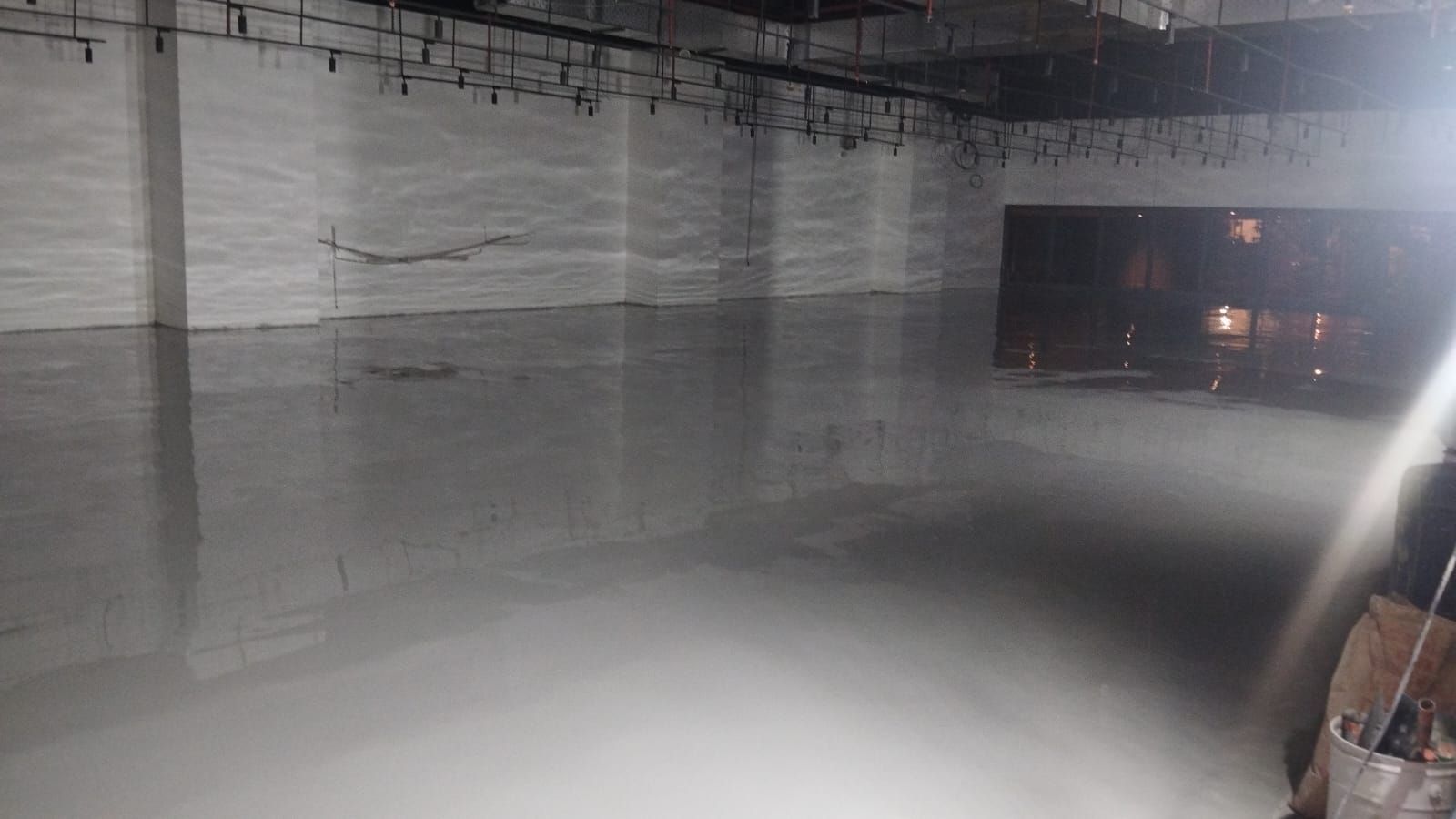 Lantai parkir K Mall dengan epoxy abu-abu di antara kolom beton (3/3)