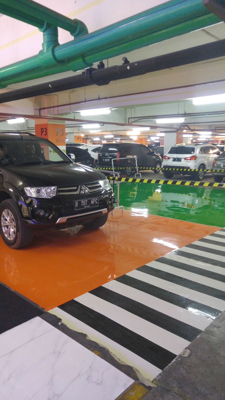 Jalur oranye dan zebra putih di lantai parkir Lippo Mall Puri (5/5)