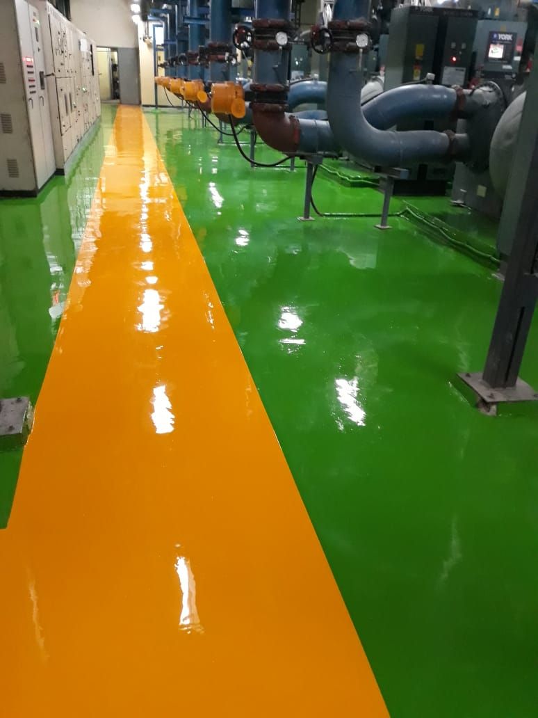 Jalur oranye di atas lantai epoxy abu-abu pada area servis Menara Mandiri