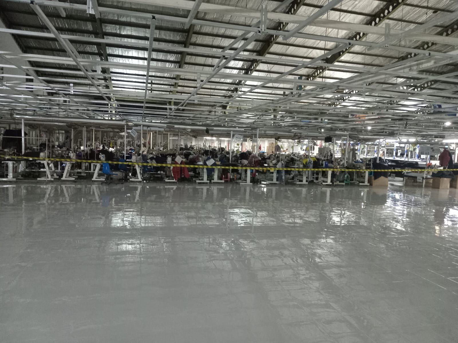 Lantai epoxy abu-abu membentang di ruang jahit PAN Brothers