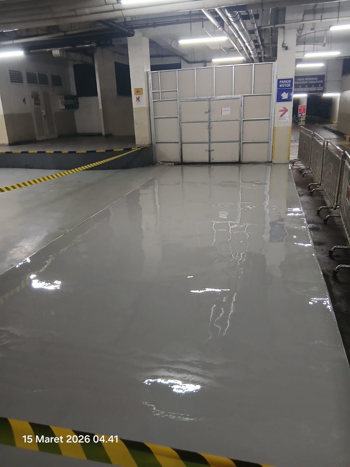 Ramp parkir PIK Avenue dengan lantai epoxy hijau dan marka kuning (2/3)