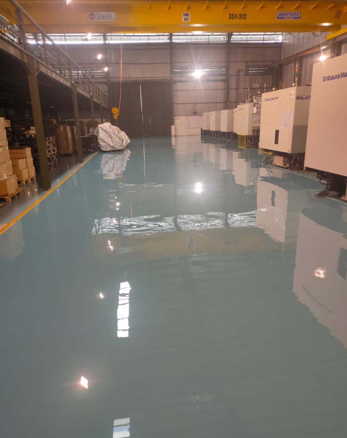 Area produksi Prima Komponen dengan lantai epoxy biru muda dan mesin di sepanjang dinding (2/4)