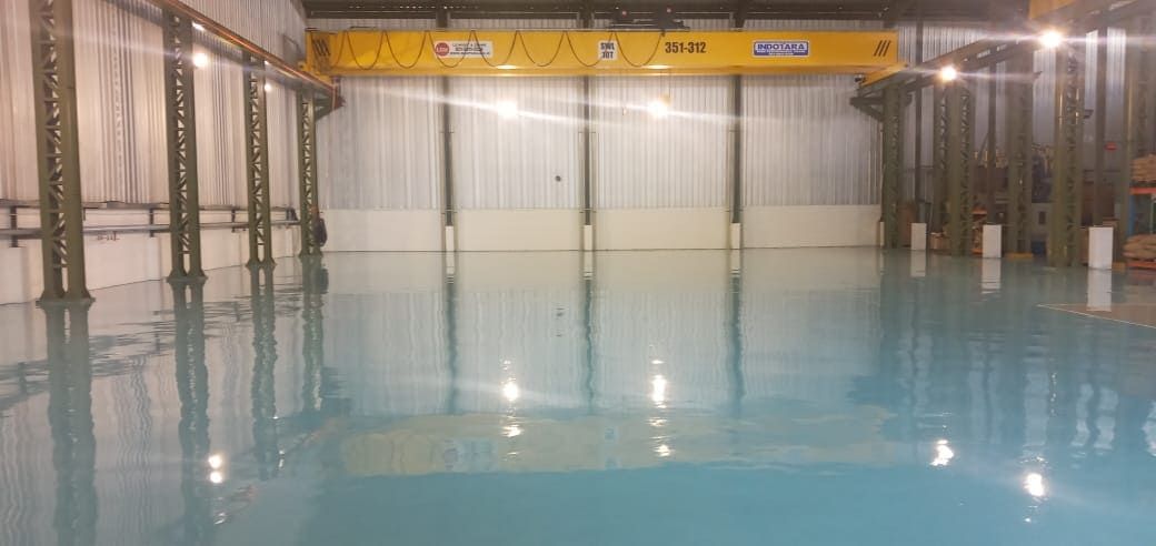 Area produksi Prima Komponen dengan lantai epoxy biru muda dan mesin di sepanjang dinding (3/4)