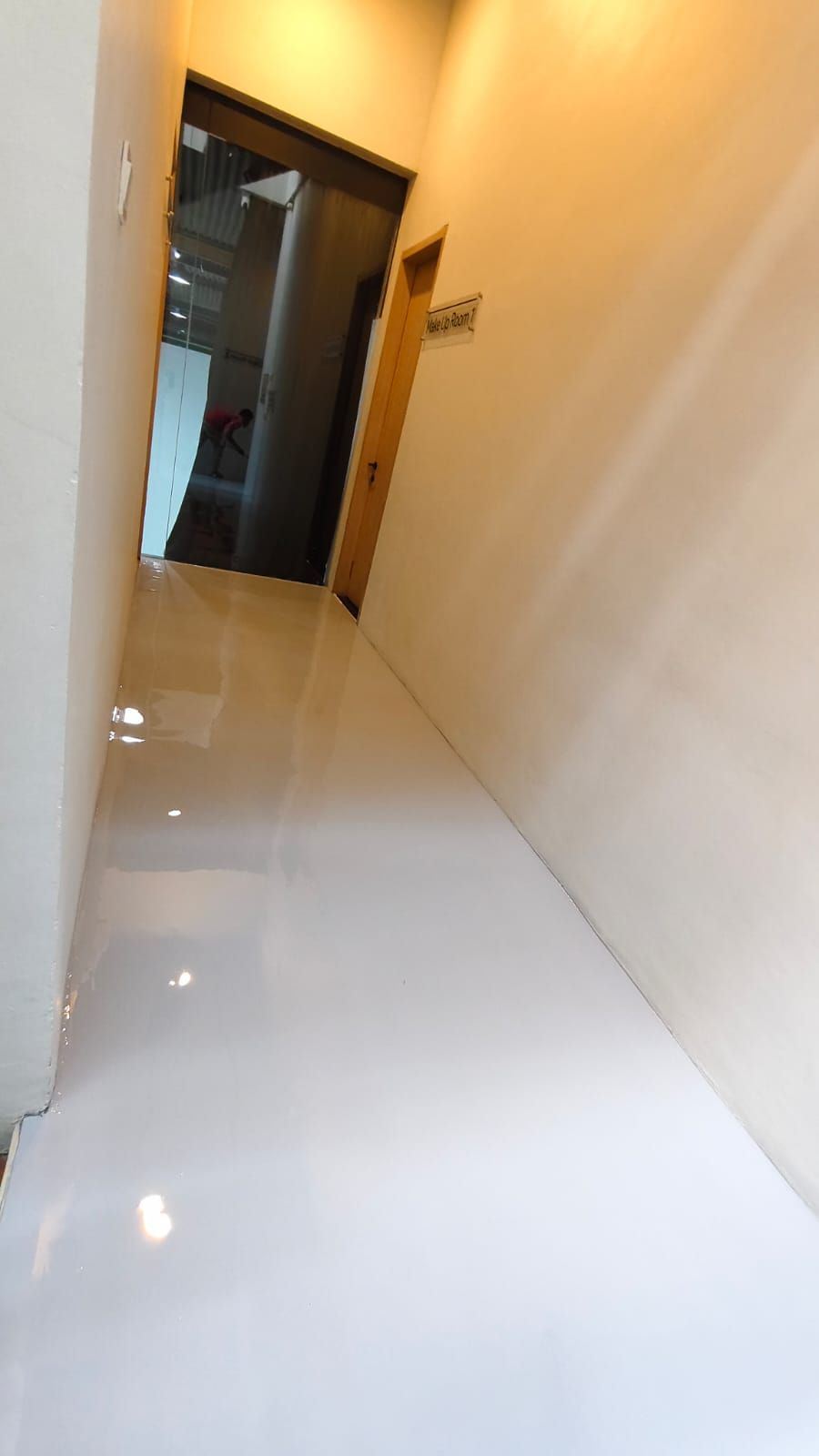Studio Shooting Star dengan lantai epoxy krem mengilap dan tangga di sudut ruang (2/2)
