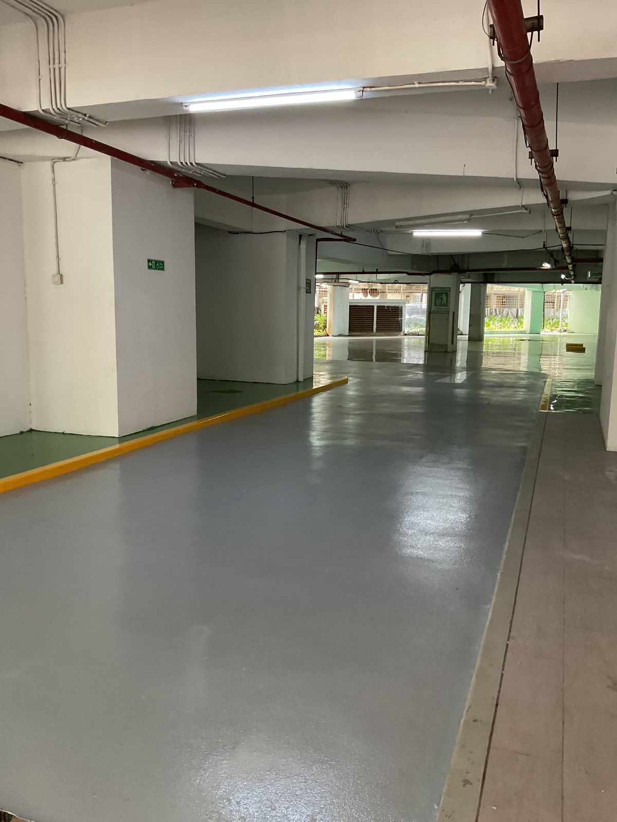 Basement parkir Springhill Royale Suites dengan lantai epoxy hijau dan marka jalur putih (2/14)