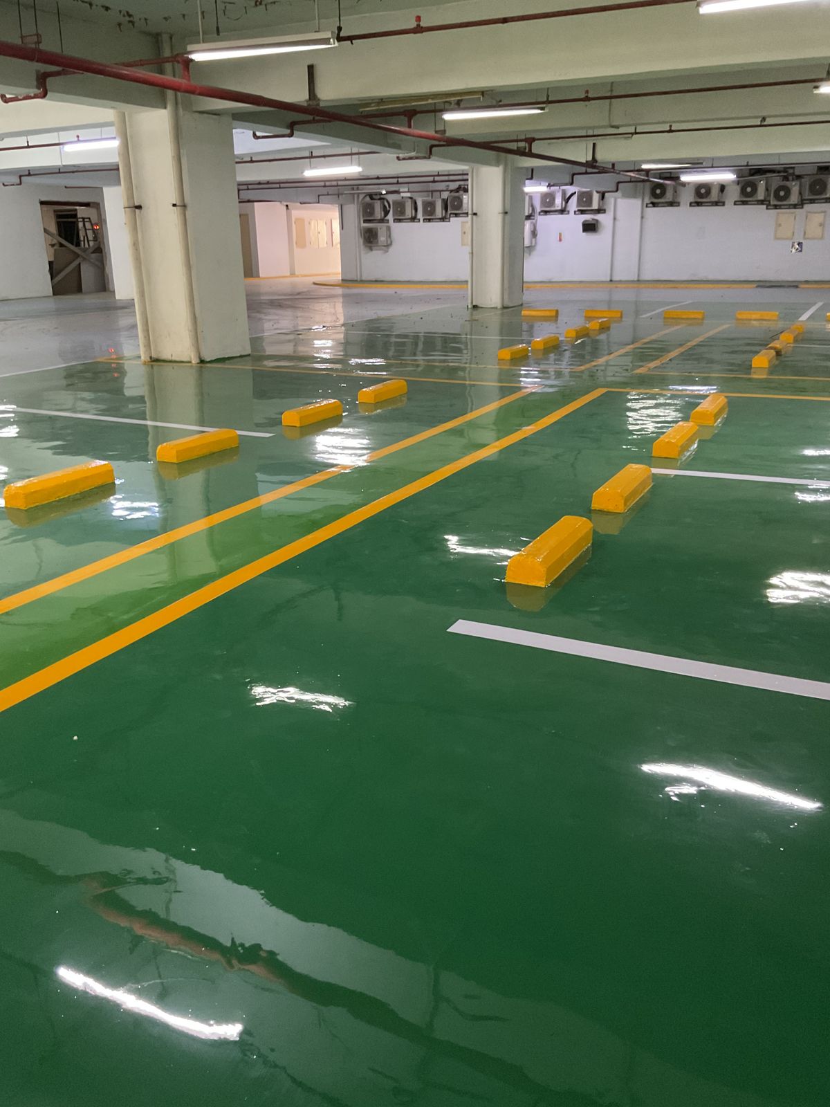 Basement parkir Springhill Royale Suites dengan lantai epoxy hijau dan marka jalur putih (3/14)