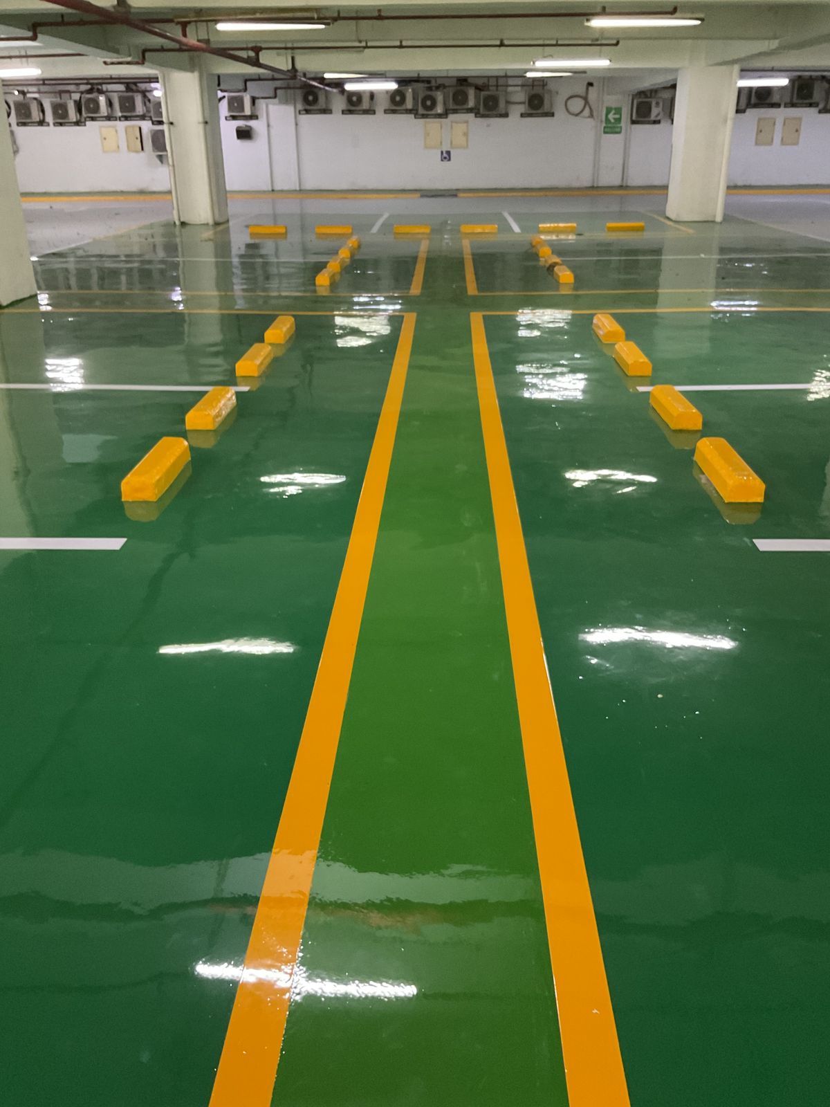 Basement parkir Springhill Royale Suites dengan lantai epoxy hijau dan marka jalur putih (4/14)