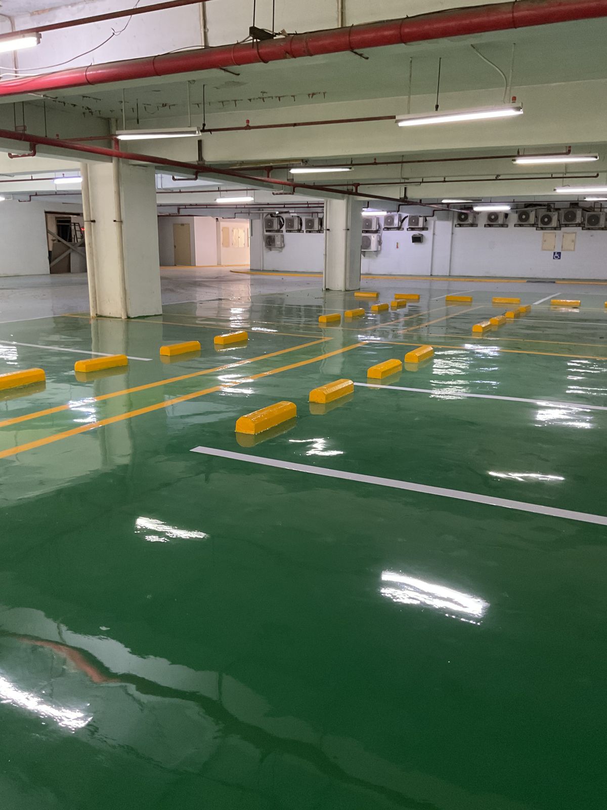 Basement parkir Springhill Royale Suites dengan lantai epoxy hijau dan marka jalur putih (5/14)