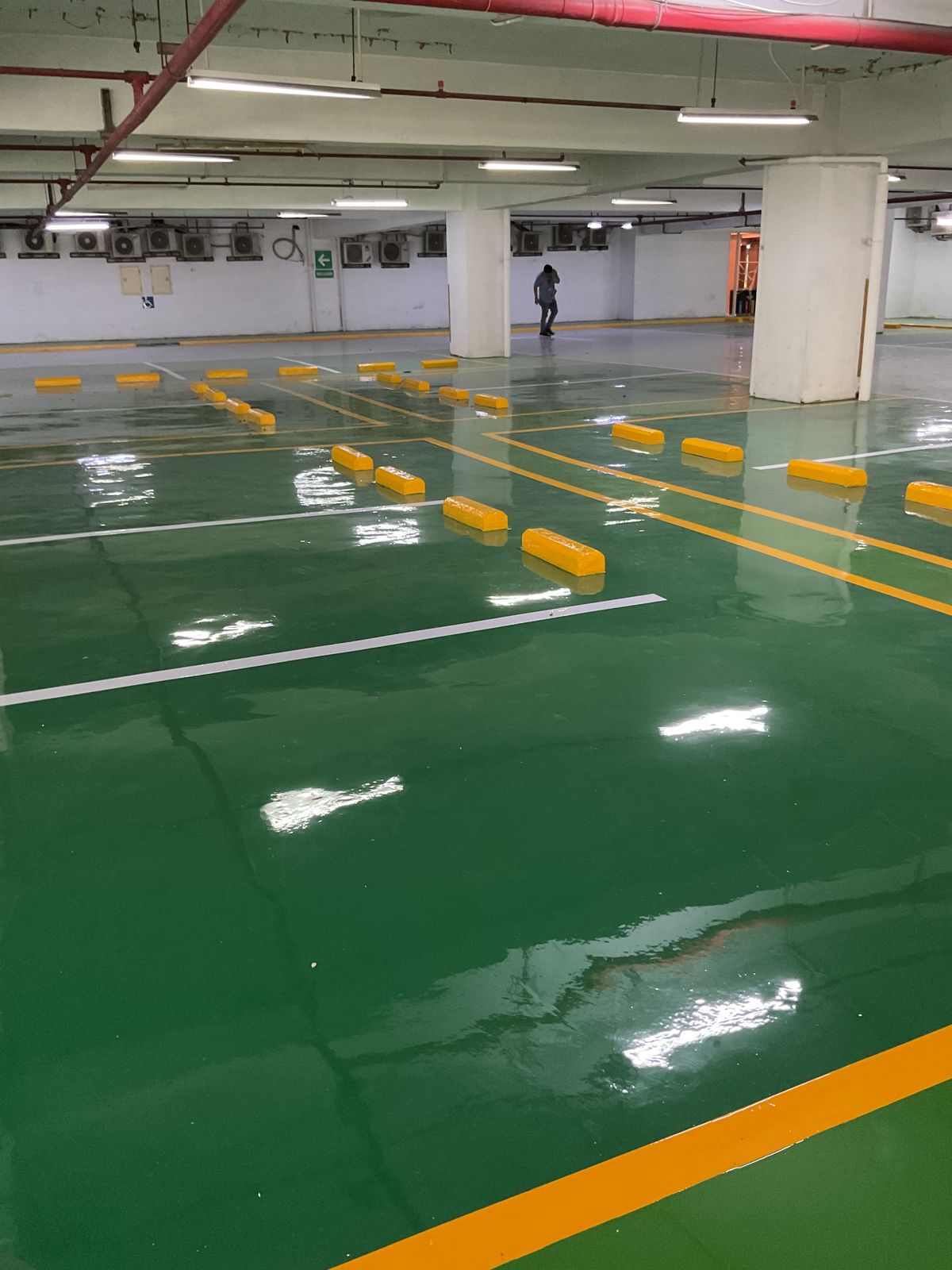 Basement parkir Springhill Royale Suites dengan lantai epoxy hijau dan marka jalur putih (6/14)