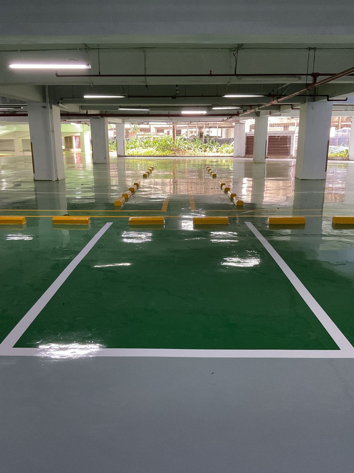 Basement parkir Springhill Royale Suites dengan lantai epoxy hijau dan marka jalur putih (7/14)