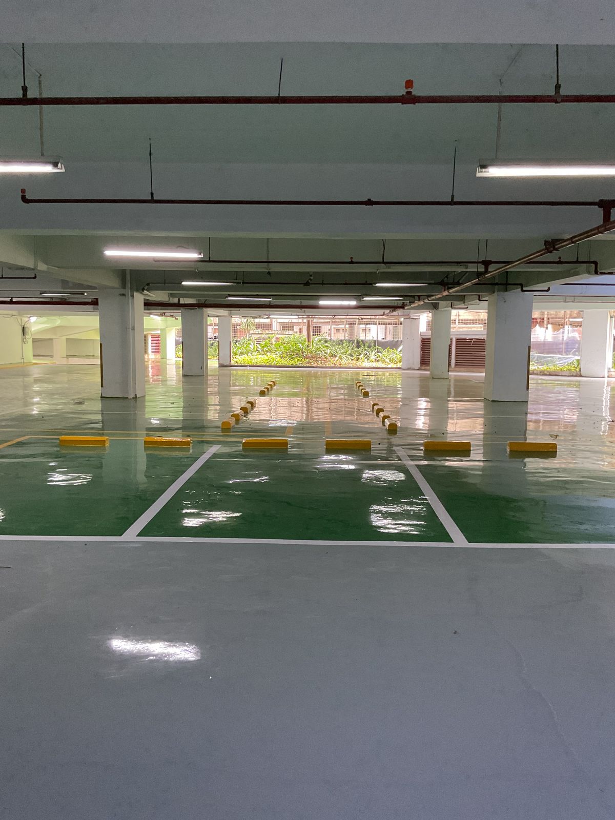 Basement parkir Springhill Royale Suites dengan lantai epoxy hijau dan marka jalur putih (8/14)