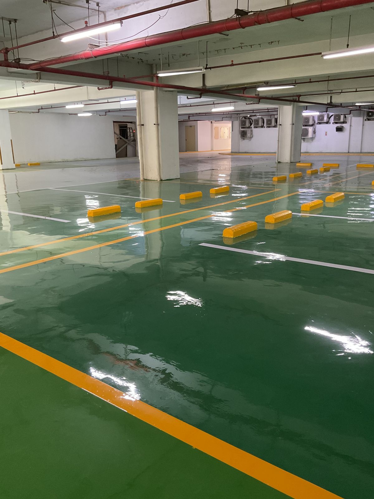Basement parkir Springhill Royale Suites dengan lantai epoxy hijau dan marka jalur putih (9/14)